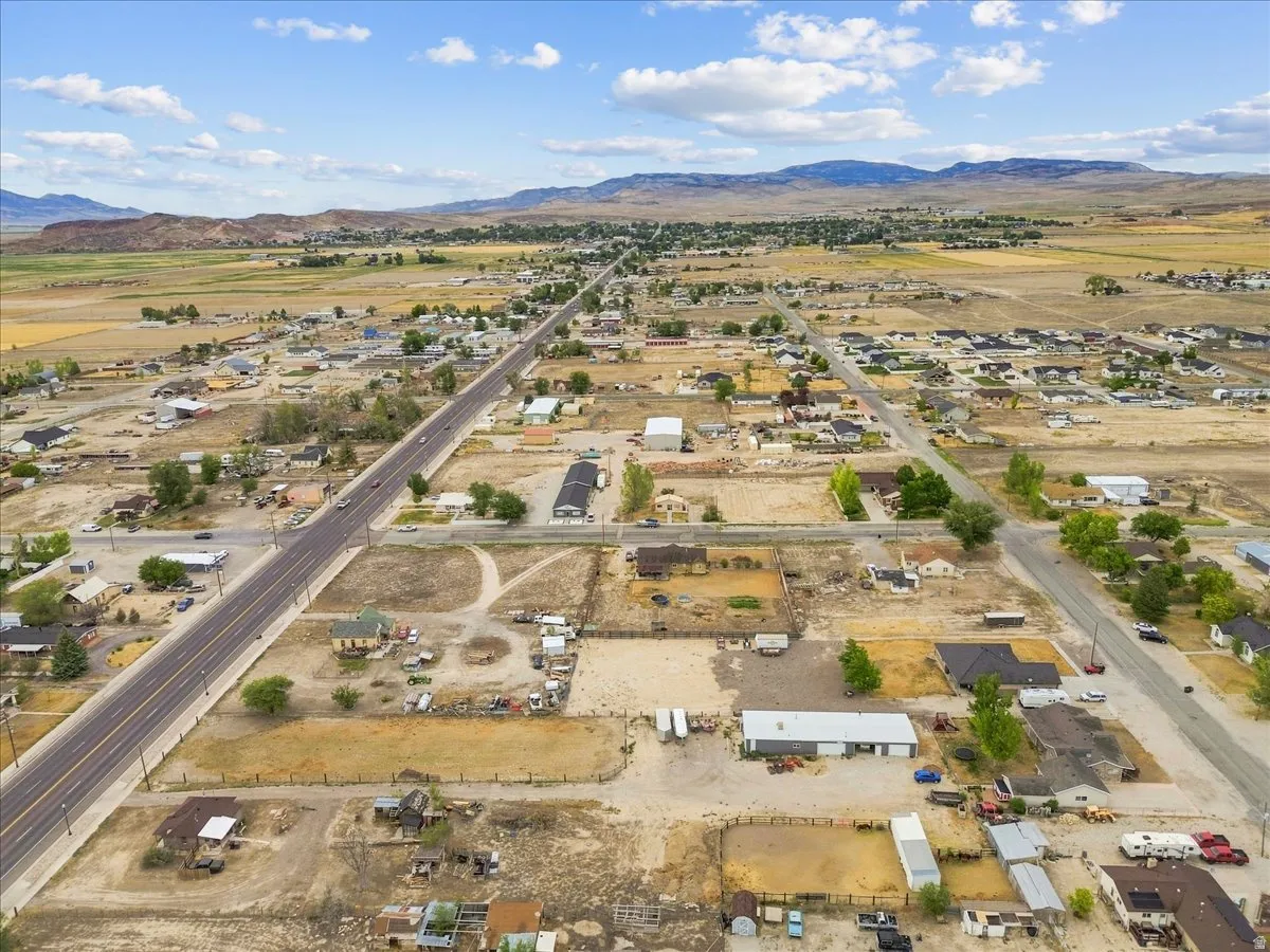 Expansive aerial perspective showcasing a rural community with varied lot sizes and a prominent two-lane highway