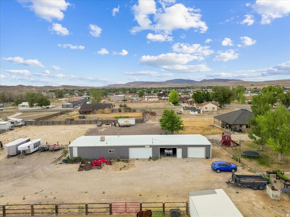 Large metal outbuilding with multiple garage doors and an expansive gravel lot