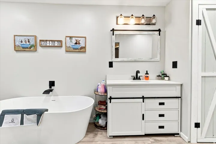 Freestanding soaking tub with a wall-mounted matte black faucet
