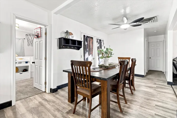 Dining area featuring wood-finish flooring and a contemporary ceiling fan with integrated lighting