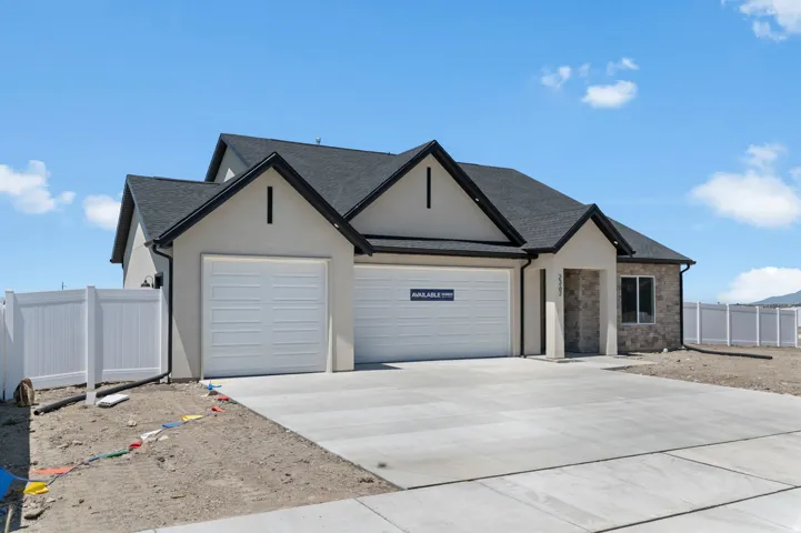Contemporary exterior featuring a stone and stucco facade, dark asphalt shingles, and a concrete driveway