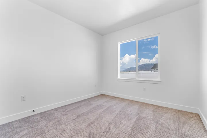 Interior room with neutral carpet, white walls, and a large window