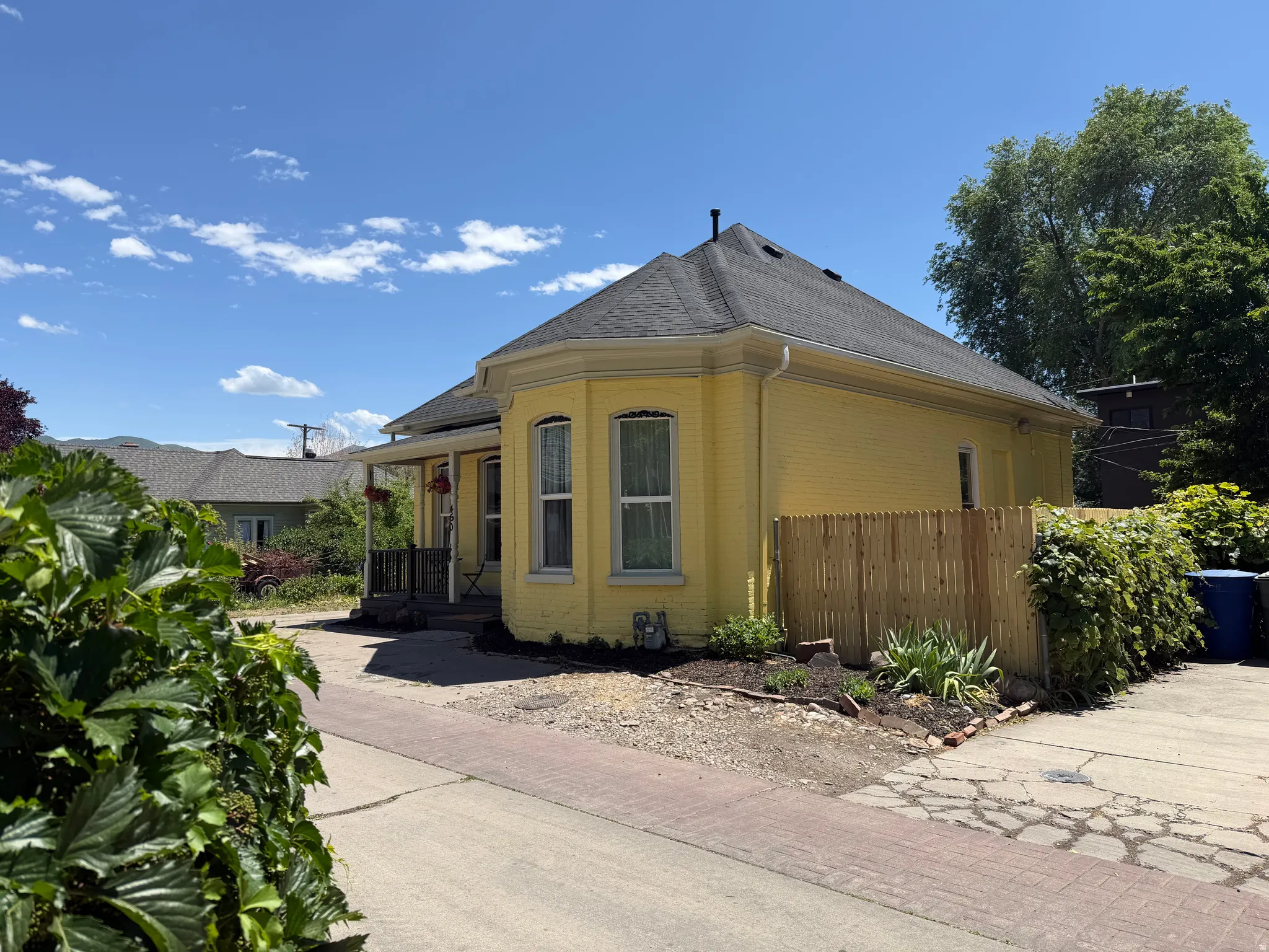 Yellow brick exterior with a dark shingle roof and white gutters