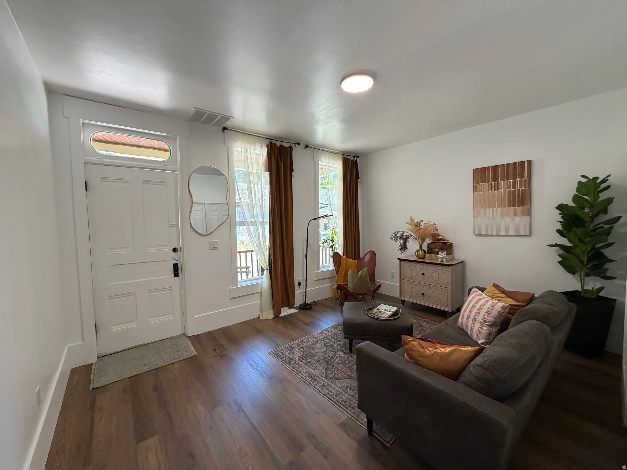 Bright living area featuring wood-finish flooring, white walls, and a recessed ceiling light
