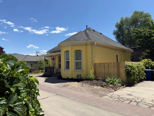 Yellow brick exterior with a dark shingle roof and white gutters