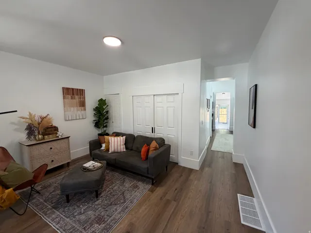 Living area featuring wood-finish flooring, white baseboards, and a flush-mount ceiling light