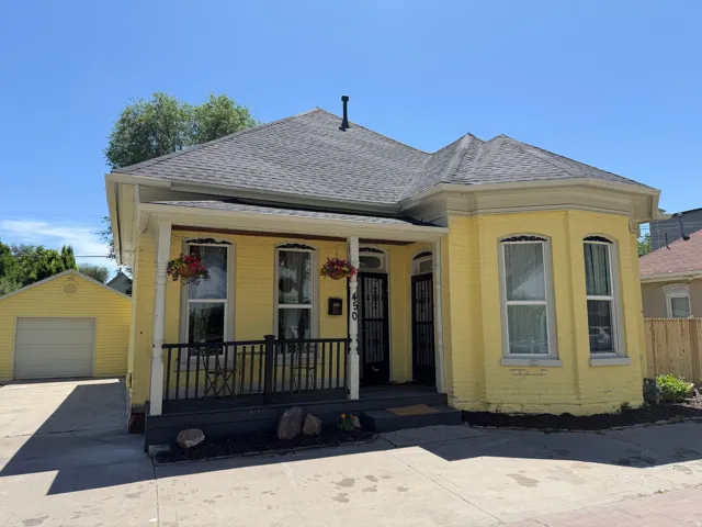 Yellow brick exterior with a gray shingle roof and white trim