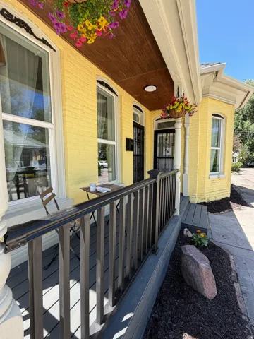 Inviting front porch featuring a dark railing system and a wood-finish ceiling