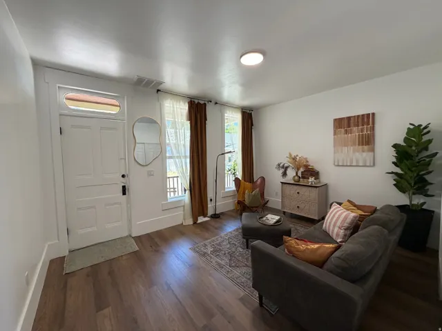 Bright living area featuring wood-finish flooring, white walls, and a recessed ceiling light