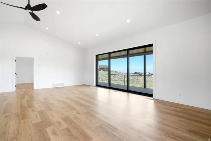 Bright interior with vaulted ceilings, recessed lighting, and a modern ceiling fan