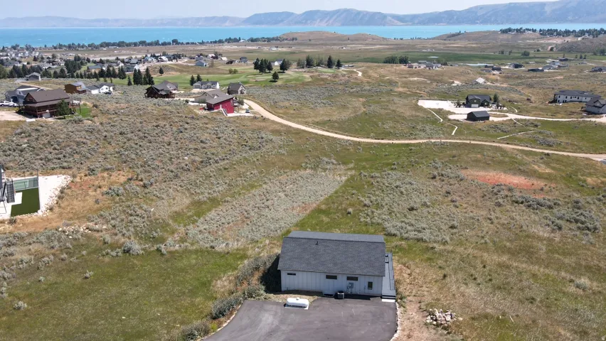 Property lot with a separate outbuilding featuring a gray shingle roof and white siding