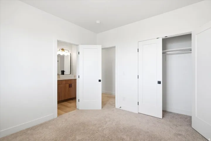 Plush carpeted flooring and white walls complement the modern interior doors with dark hardware