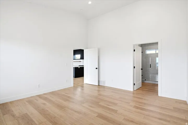 Bright interior space featuring vaulted ceilings and light wood-finish flooring