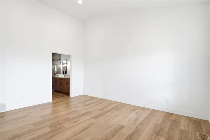 Spacious room featuring wood-finish flooring and a bright white paint palette