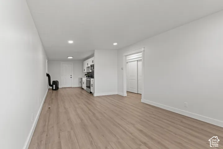 Interior space featuring wood-finish flooring, recessed lighting, white cabinetry, and multi-panel interior doors