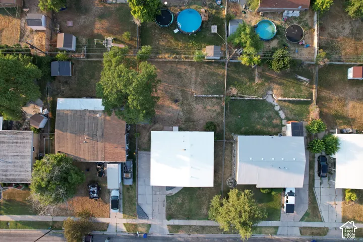 Aerial property view with a light-colored roof and an extensive rear yard