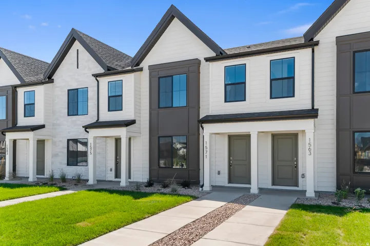 Modern townhome exterior featuring a white facade with dark trim accents