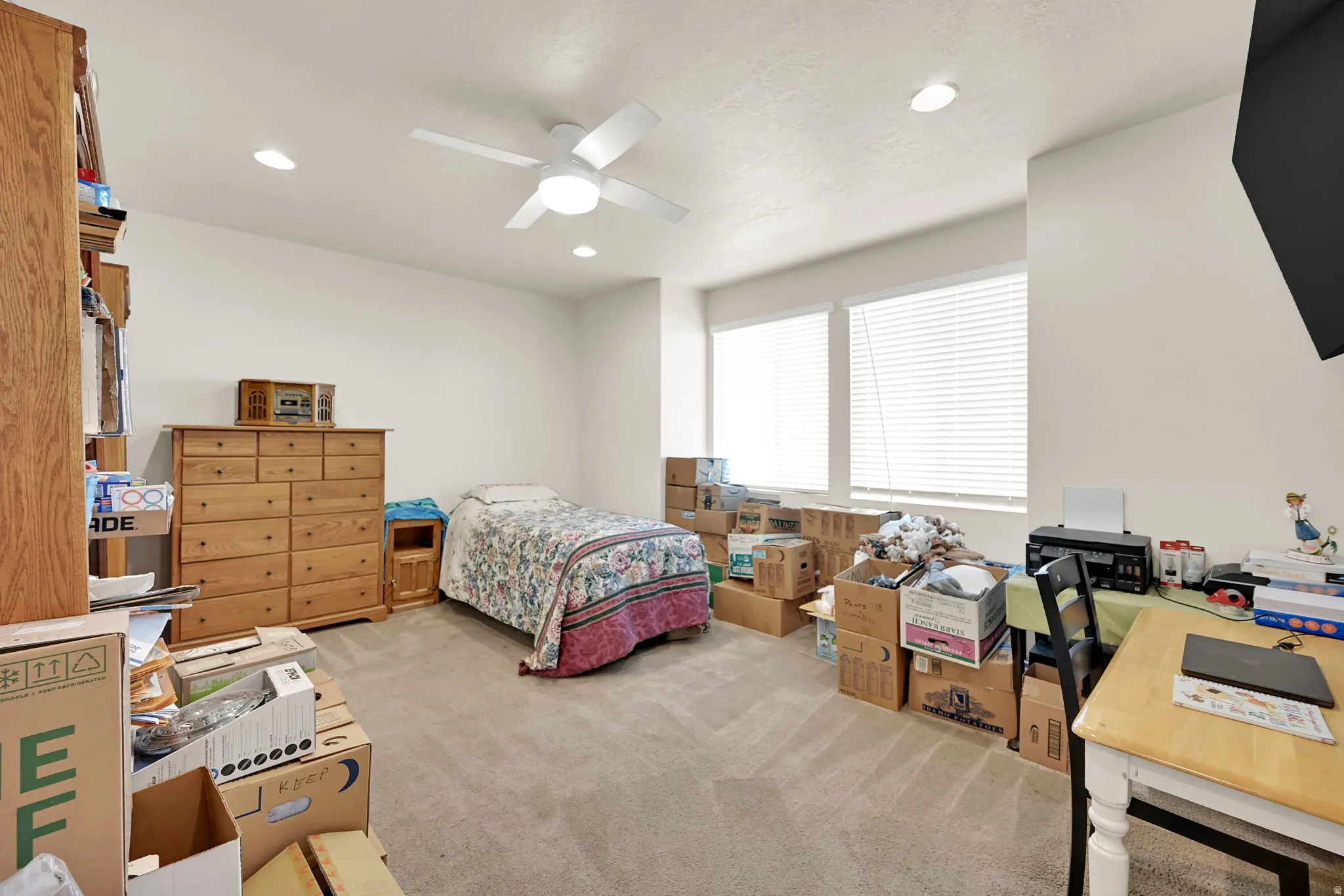 Carpeted room featuring a ceiling fan with integrated lighting, recessed lighting, and two windows with blinds
