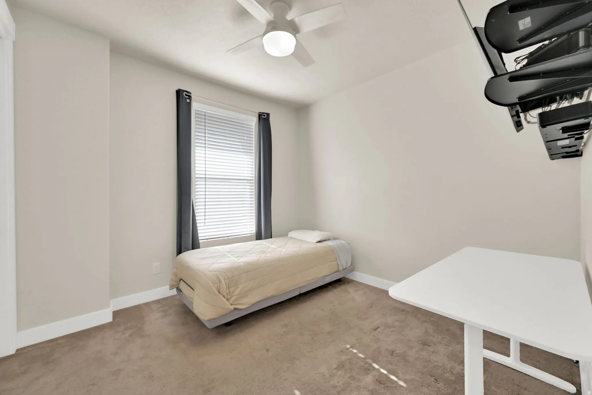 Carpeted room with a ceiling fan