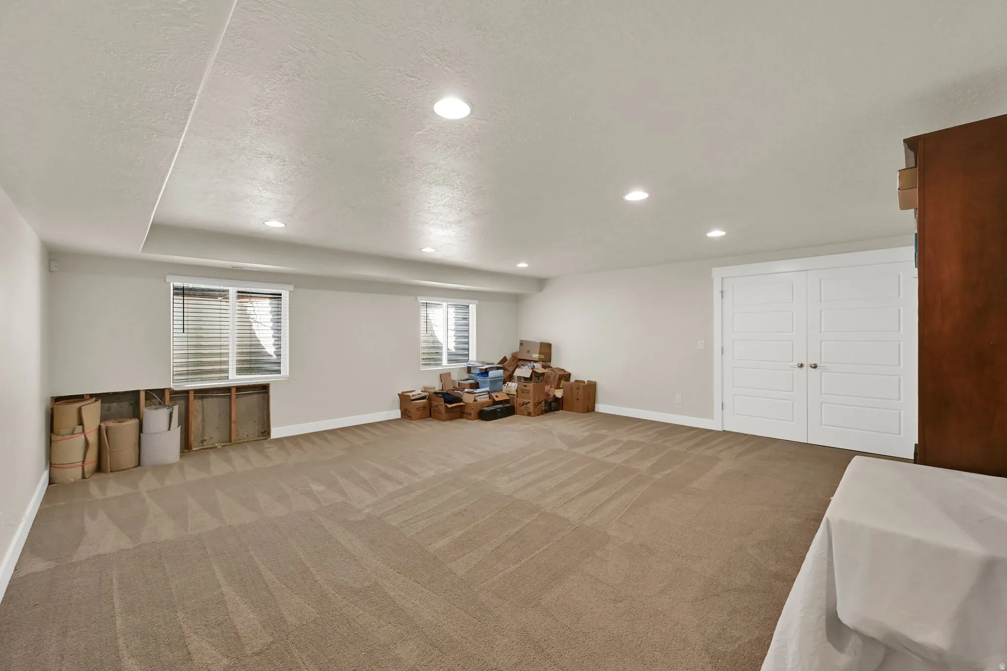 Spacious room with recessed lighting and neutral-toned carpet flooring