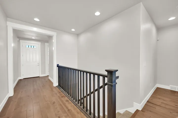Entryway featuring wood-finish flooring, recessed lighting, and a white paneled front door with upper lites