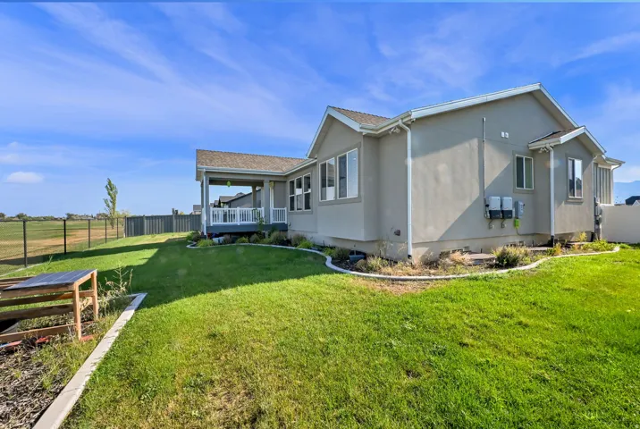 Expansive green lawn surrounds a stucco-exterior residence