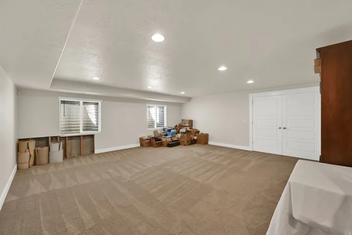 Spacious room with recessed lighting and neutral-toned carpet flooring