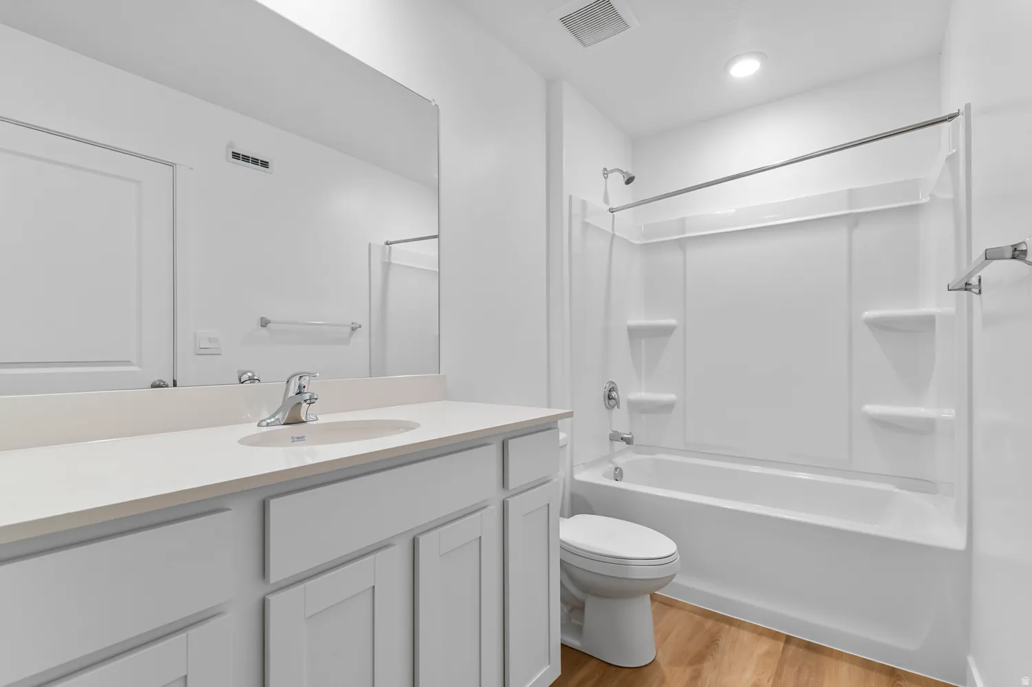 Bright and spa-like primary bathroom featuring a dual-sink vanity with ample storage cabinetry, quartz countertop, and chrome fixtures