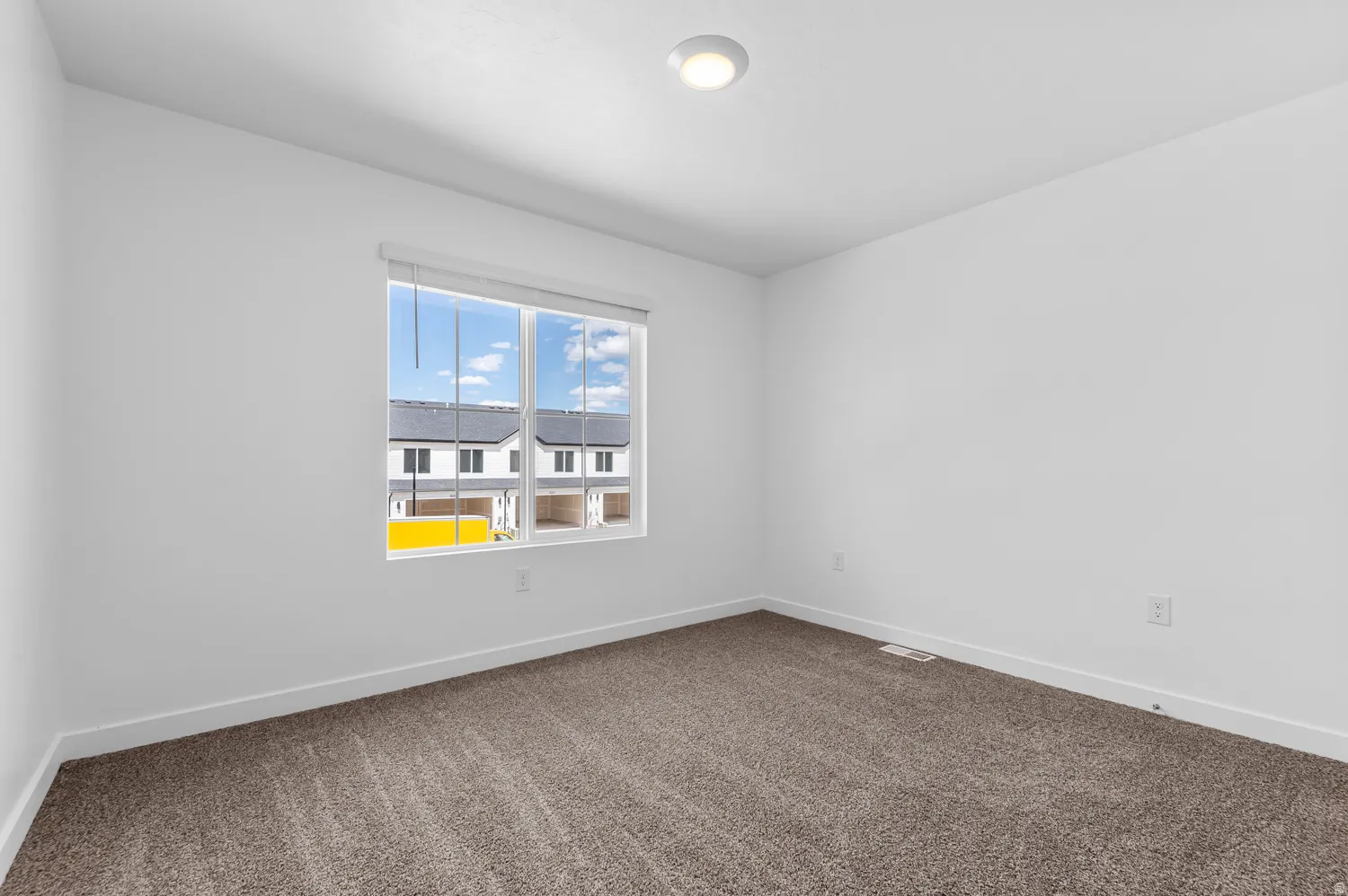 Bright interior space featuring a large window with roller shades