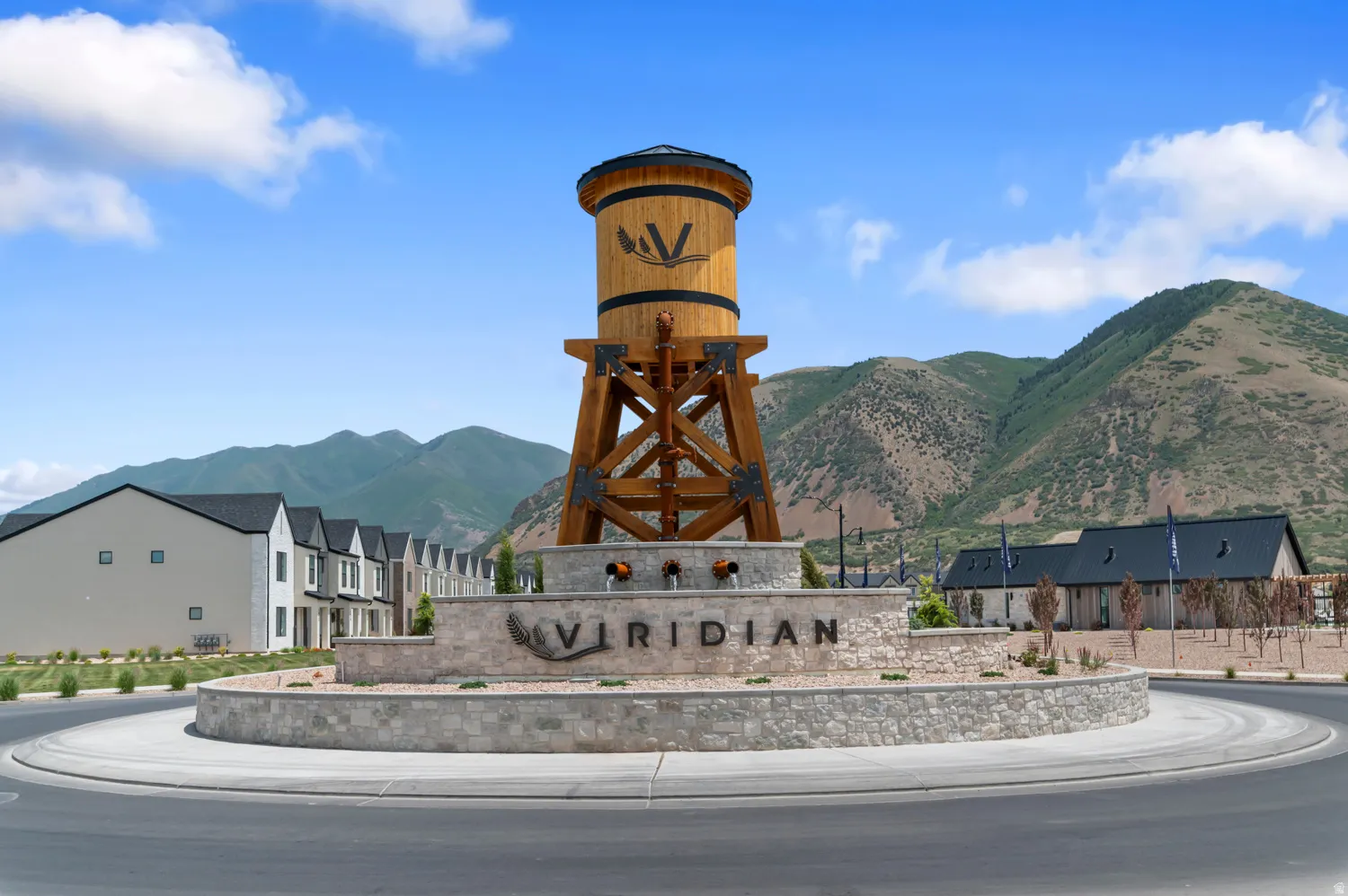 Central water tower-inspired monument featuring a circular stone base with integrated signage