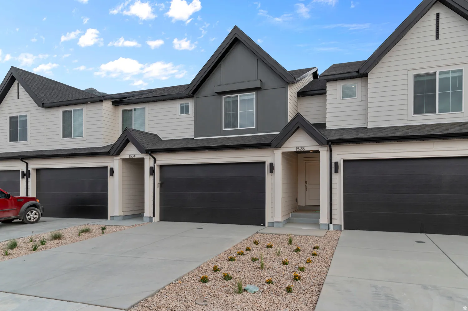 Contemporary townhome exterior featuring light-colored siding with dark gray accents