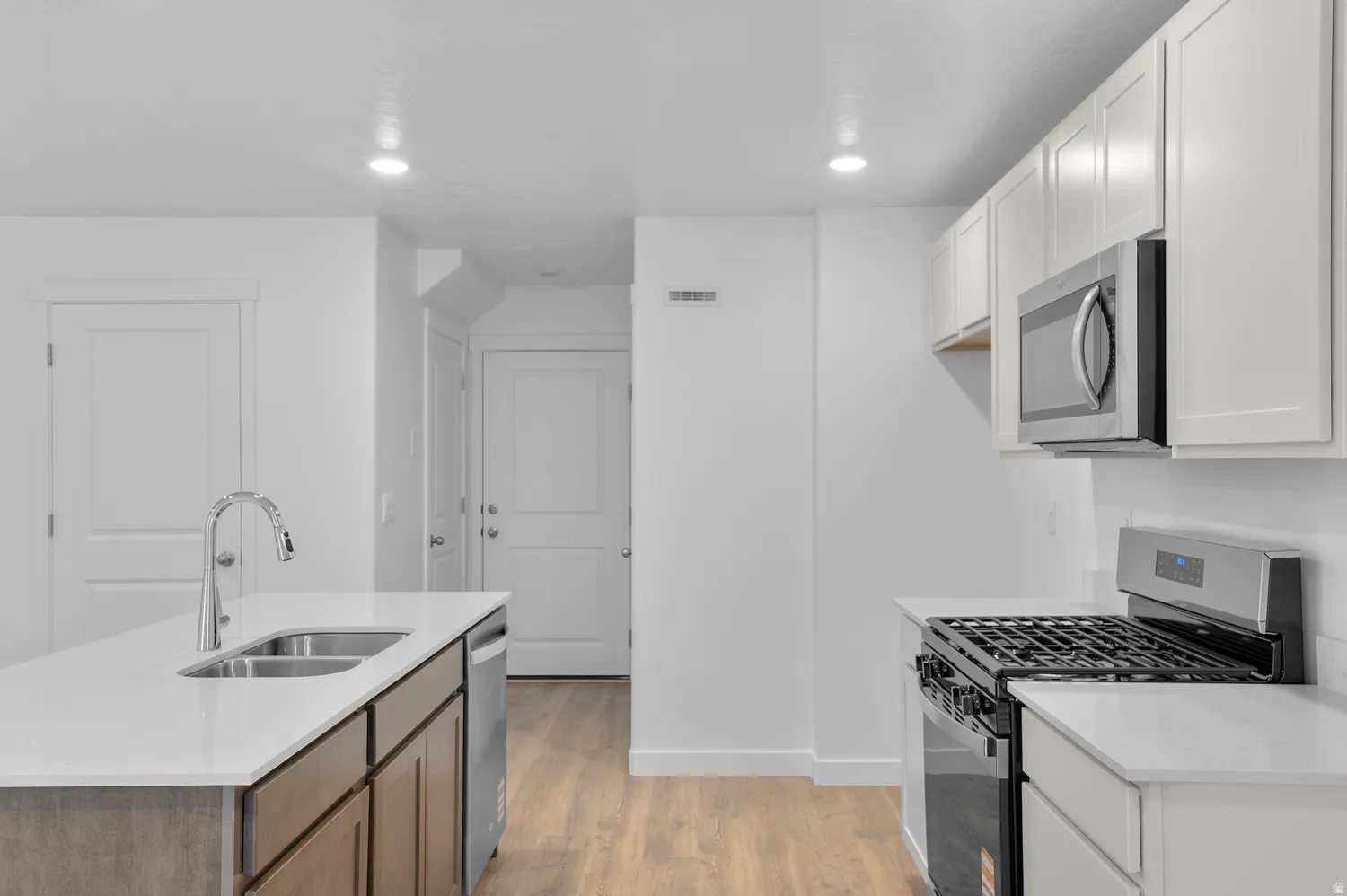 Modern kitchen featuring white cabinetry and light countertops