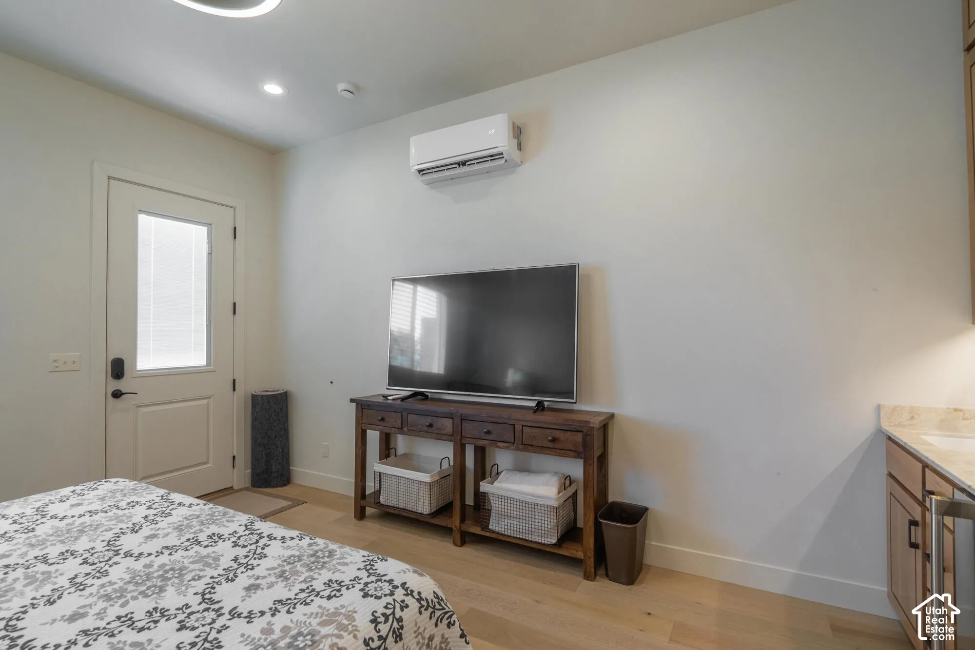 Light wood-finish flooring complements the neutral wall color