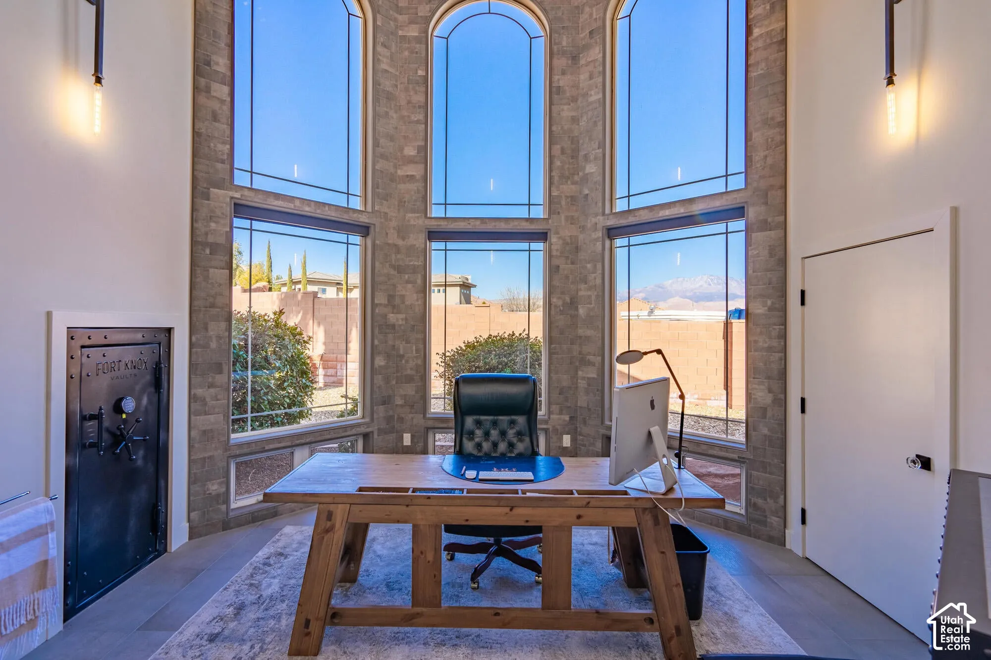 Two-story window wall featuring arched upper transoms and stone veneer surround