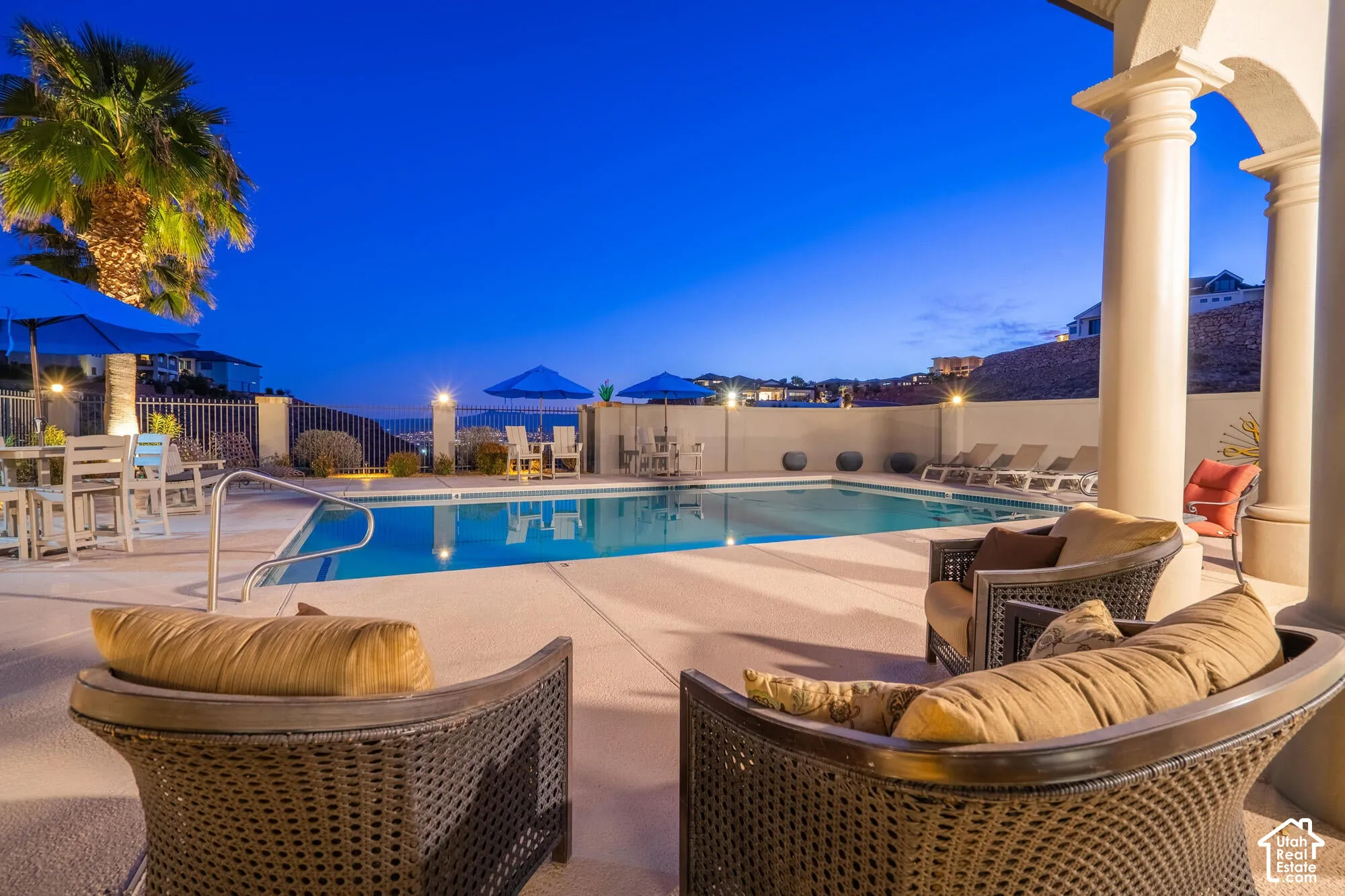 Expansive outdoor entertaining area featuring a large swimming pool with integrated steps, surrounded by a broad concrete deck