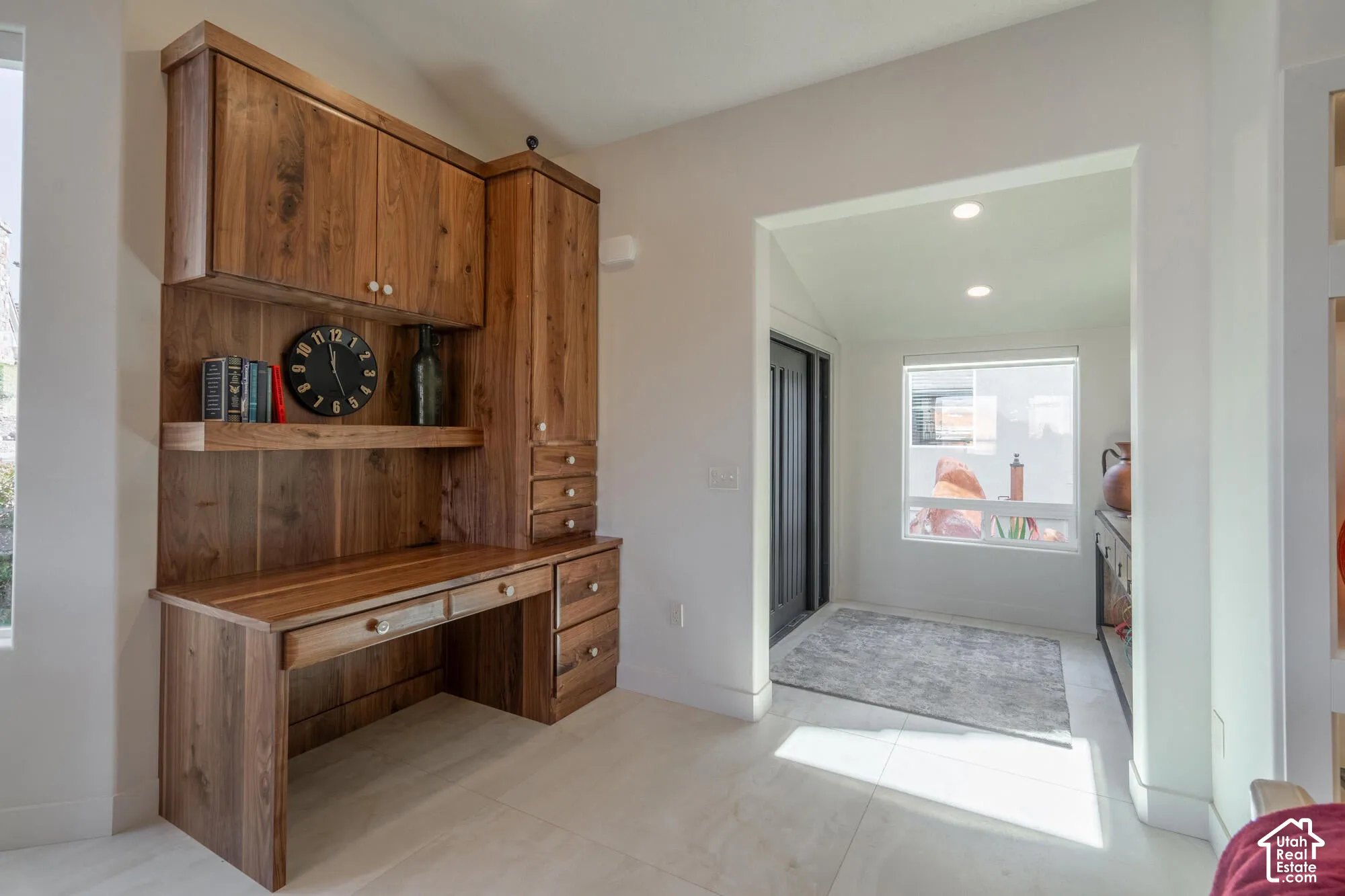 Built-in wood desk with overhead cabinetry, open shelving, and integrated drawers
