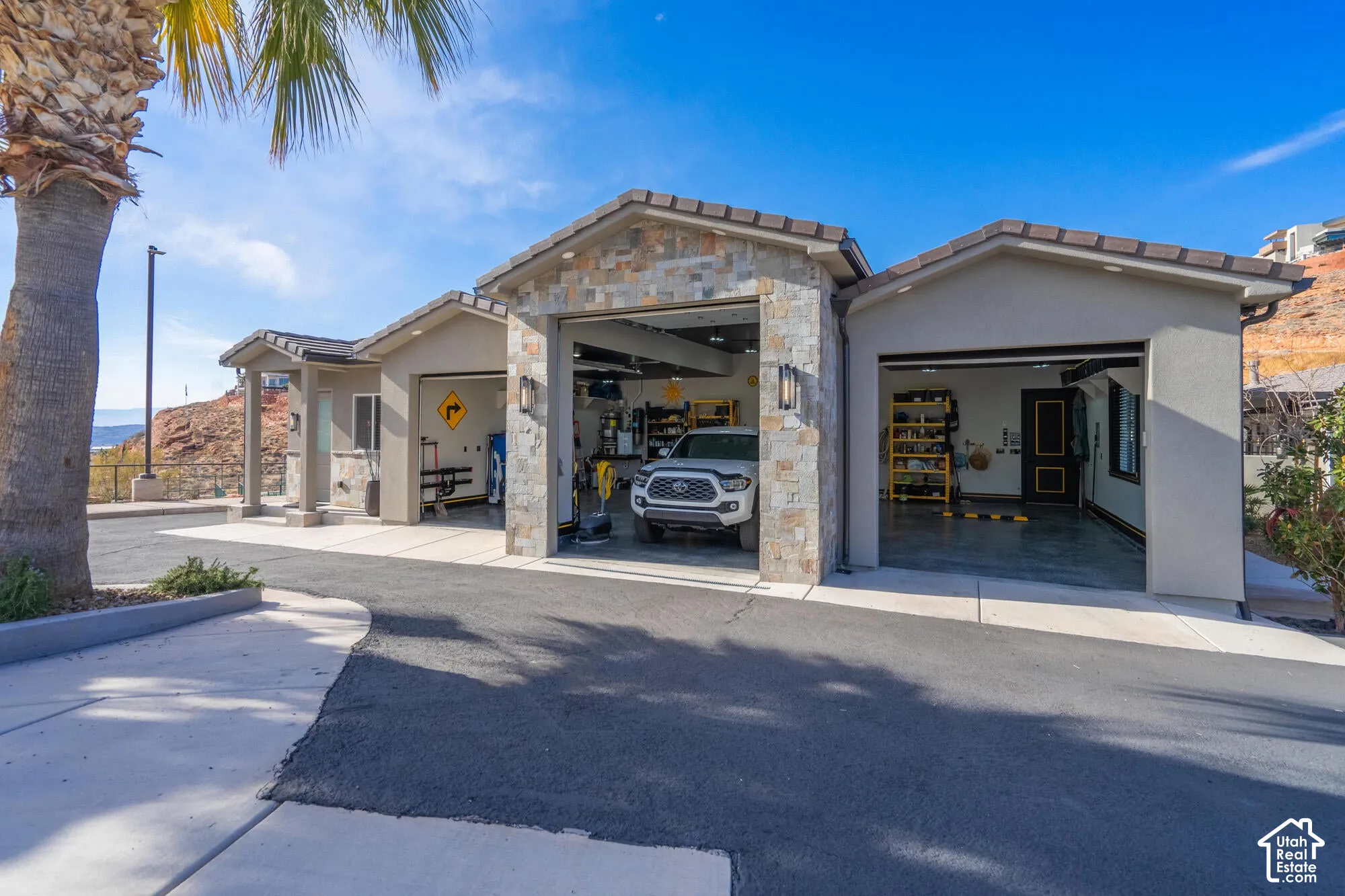 Multi-bay garage featuring stone accents and stucco exterior