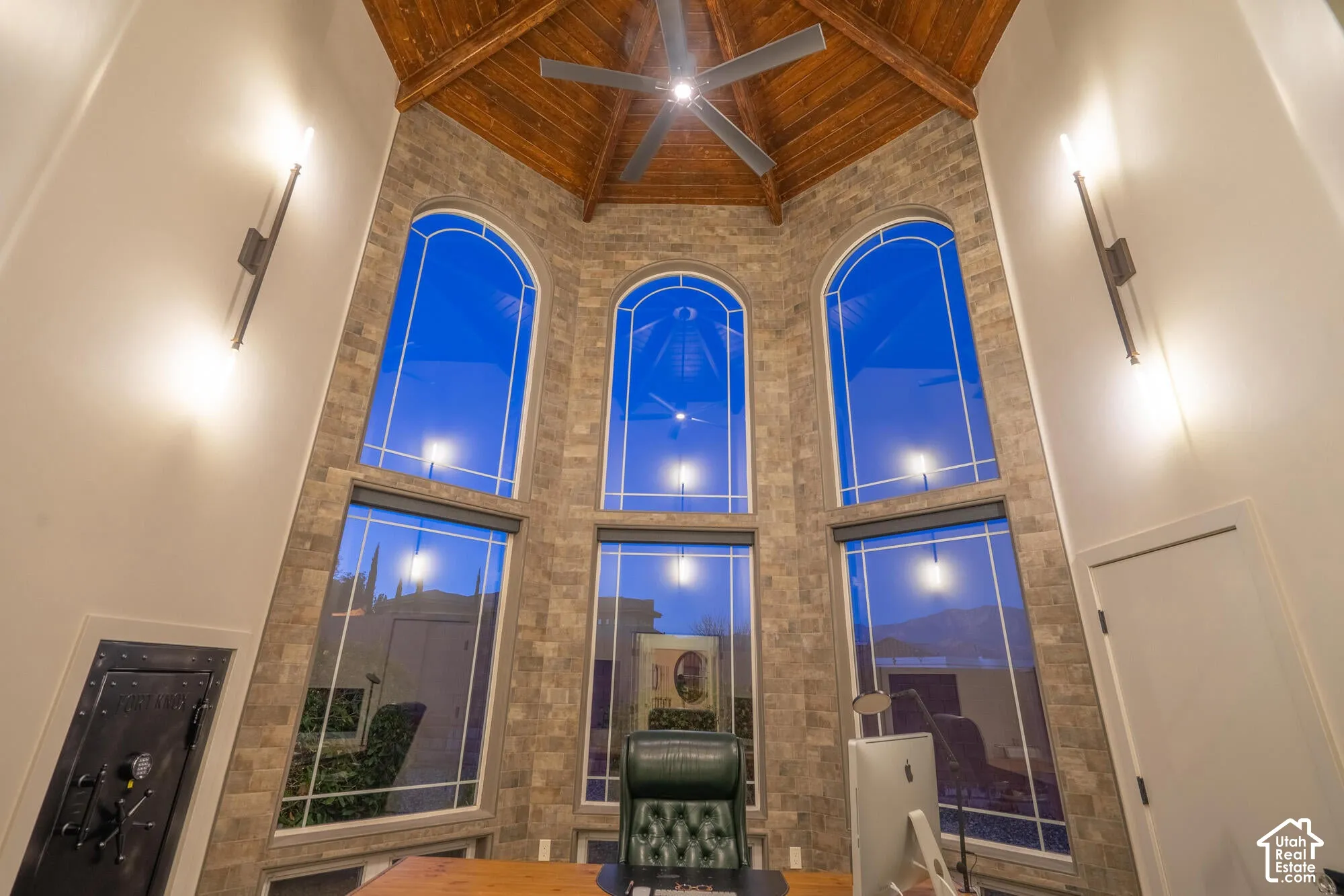 Soaring vaulted ceiling with wood-finish planks and a ceiling fan