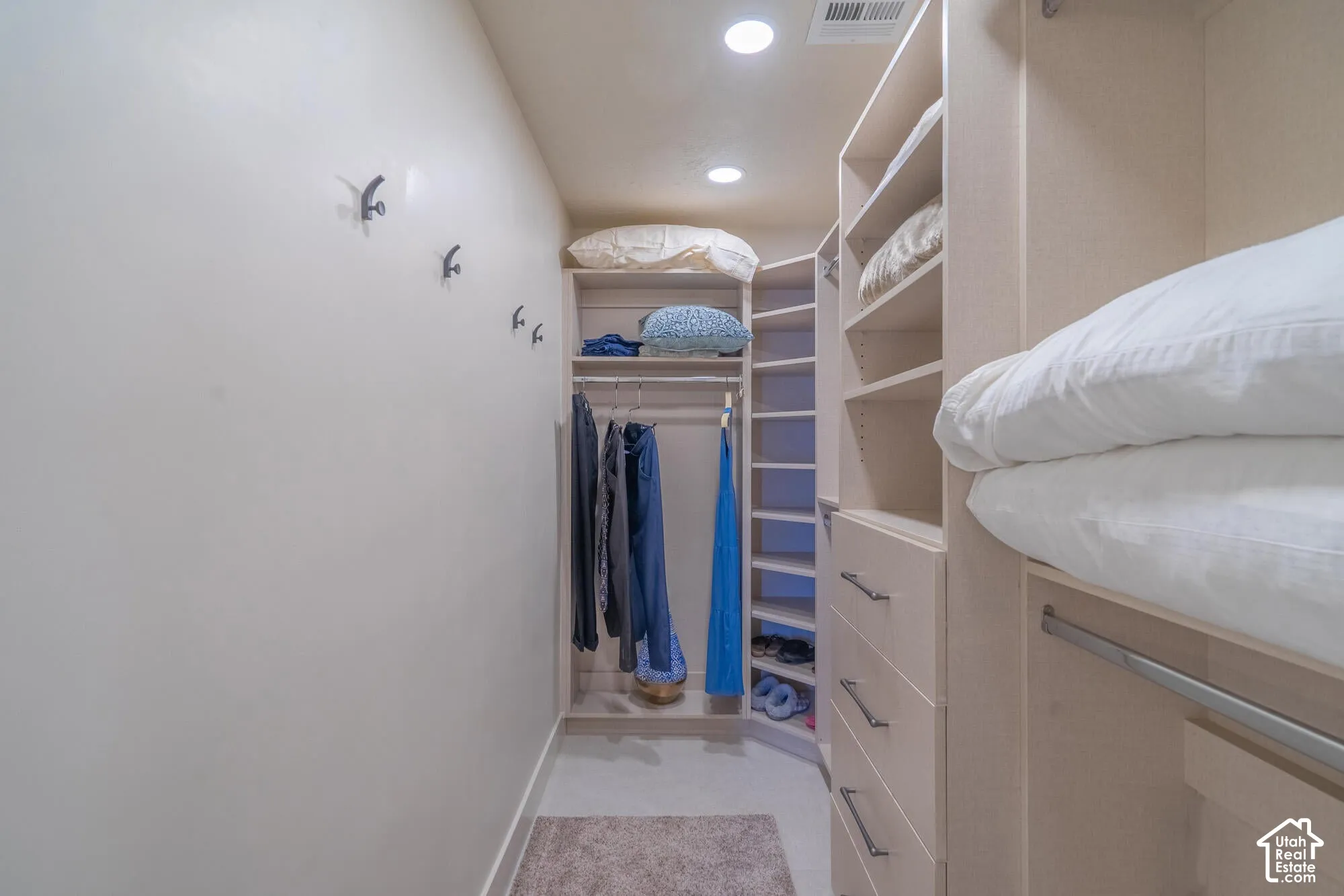 Custom storage system featuring multiple shelving units, drawers with bar pulls, and hanging rods