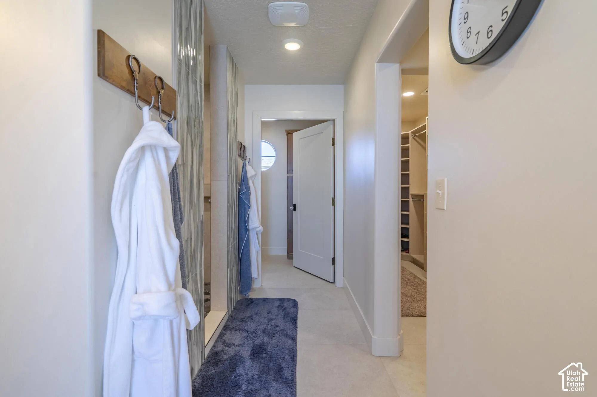 Hallway featuring recessed lighting, light-toned walls, and a built-in wall-mounted coat rack