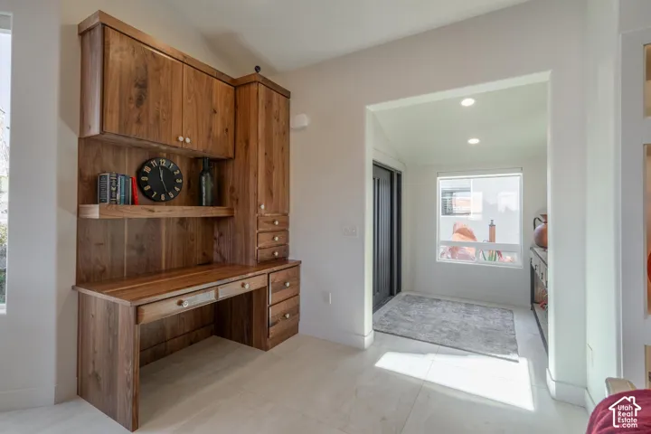 Built-in wood desk with overhead cabinetry, open shelving, and integrated drawers