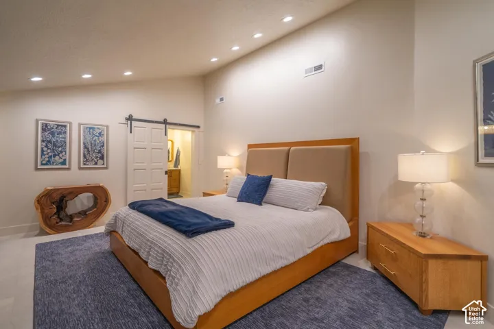 Vaulted ceiling bedroom featuring recessed lighting, light-toned walls, and wood-finish flooring