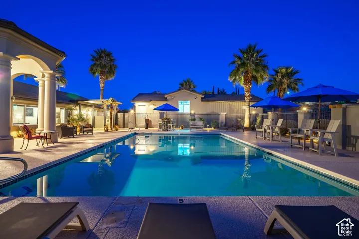 Expansive swimming pool with integrated lighting, surrounded by a textured concrete deck