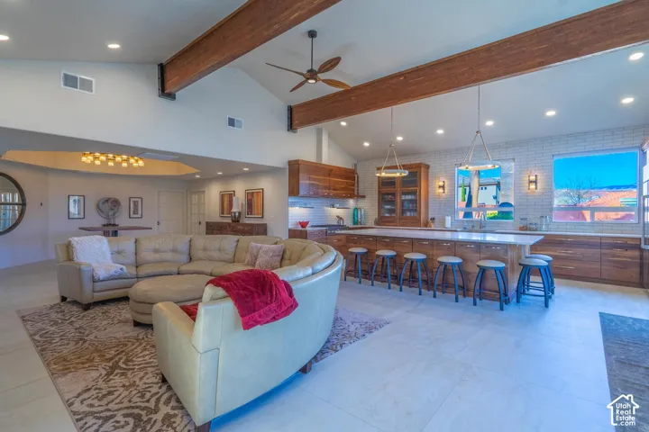 Open-concept living space featuring wood-finish ceiling beams, vaulted ceilings, and recessed lighting