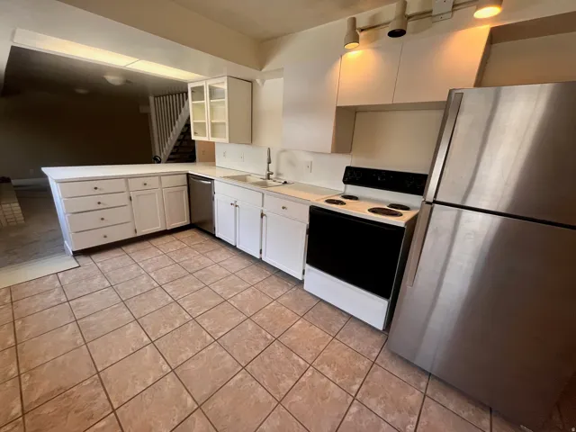 East Side - Kitchen featuring white cabinetry, light countertops, and tile flooring