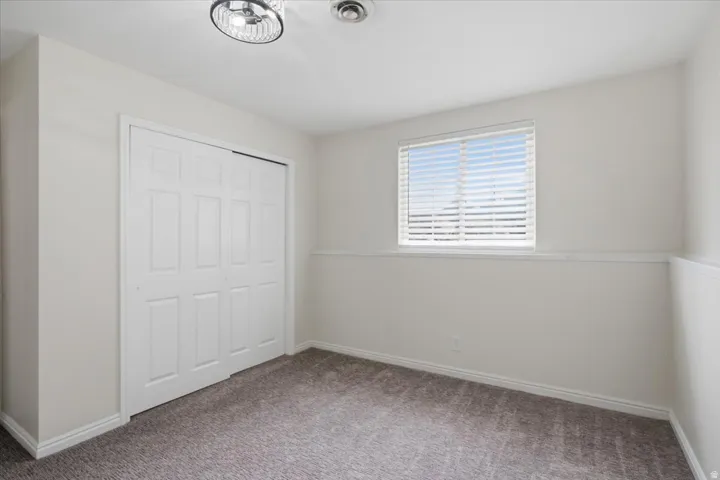 Neutral-toned carpet flooring and white baseboards
