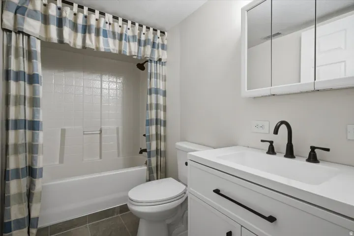Bathroom featuring a white vanity with integrated sink, black matte faucet, and matching cabinet pulls