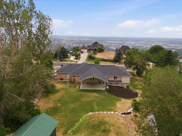 Aerial perspective showcasing a single-story residence with an attached garage and a dark shingle roof