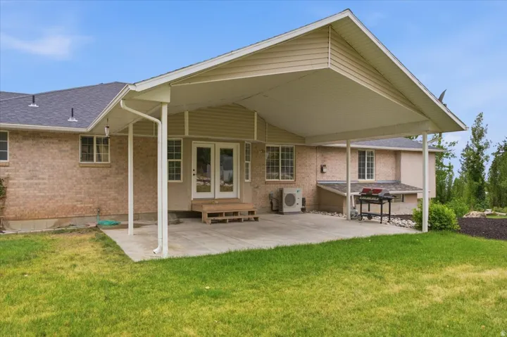 Expansive covered patio featuring a concrete surface, supported by white columns