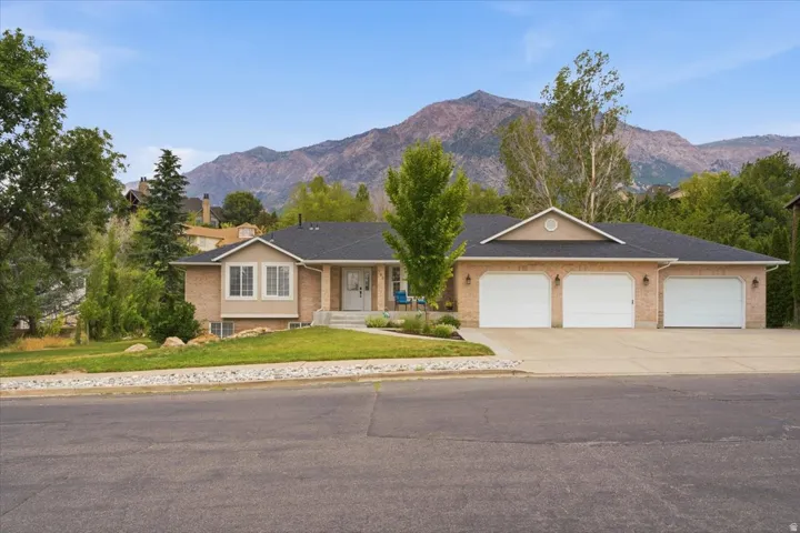 Brick and siding exterior residence with an attached three-car garage and a paved driveway